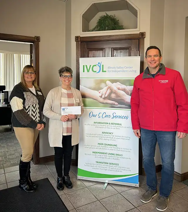 John Riva from CPCC presents a check to Beth Rockford, Associate Director, and Marie Argubright, Executive Director of IVCIL
